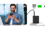 Man using a smartphone with a laptop, charging cable, and battery indicator on a white background